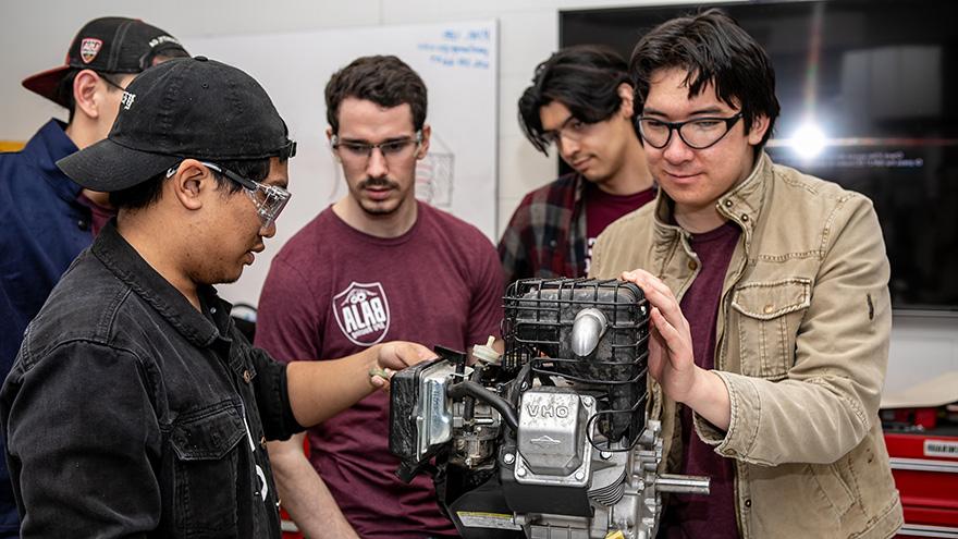 Baja racing club members work on an engine