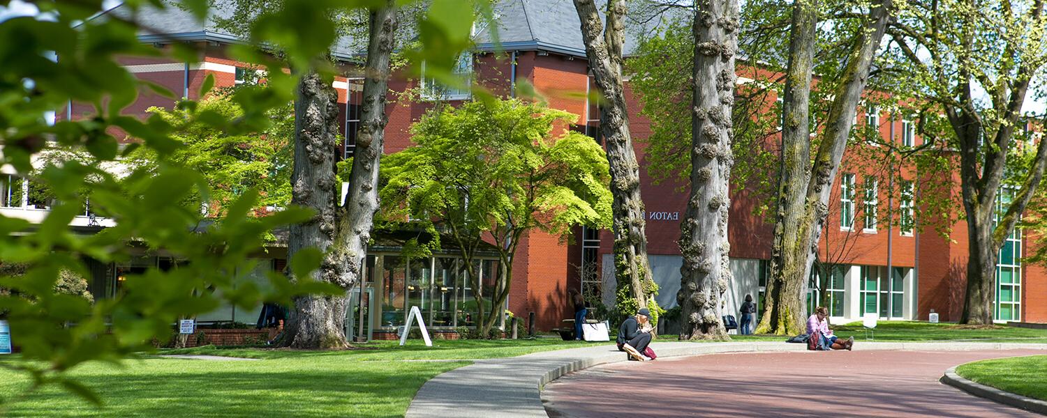 Students sit along the curb surrounding Tiffany Loop, near Eaton Hall. 